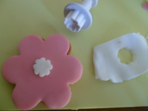 Adesso decoriamo il biscotto a forma di fiore: ritagliate un piccolo fiorellino con la pdz bianca e applicatelo al centro.